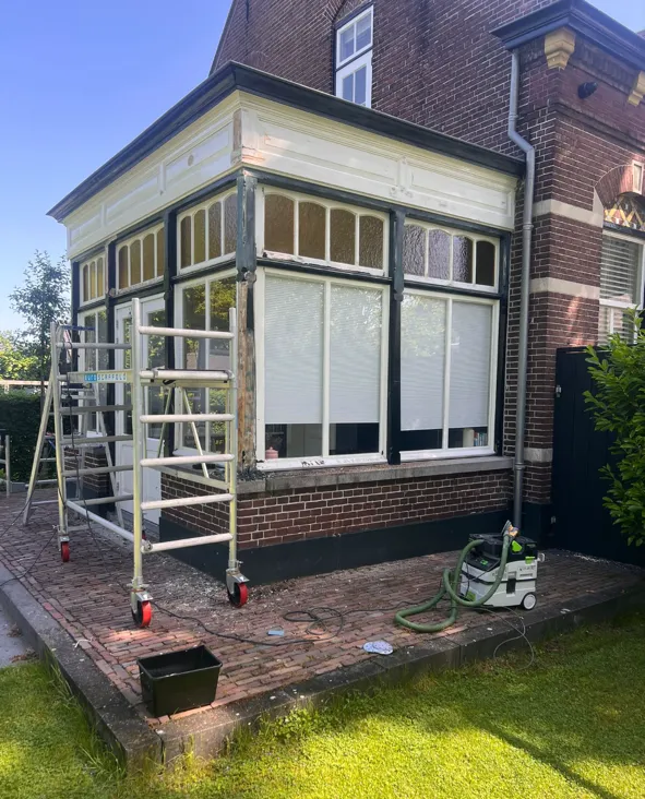 Serre in uitvoering: het houtwerk wordt vanaf de steiger geschilderd.