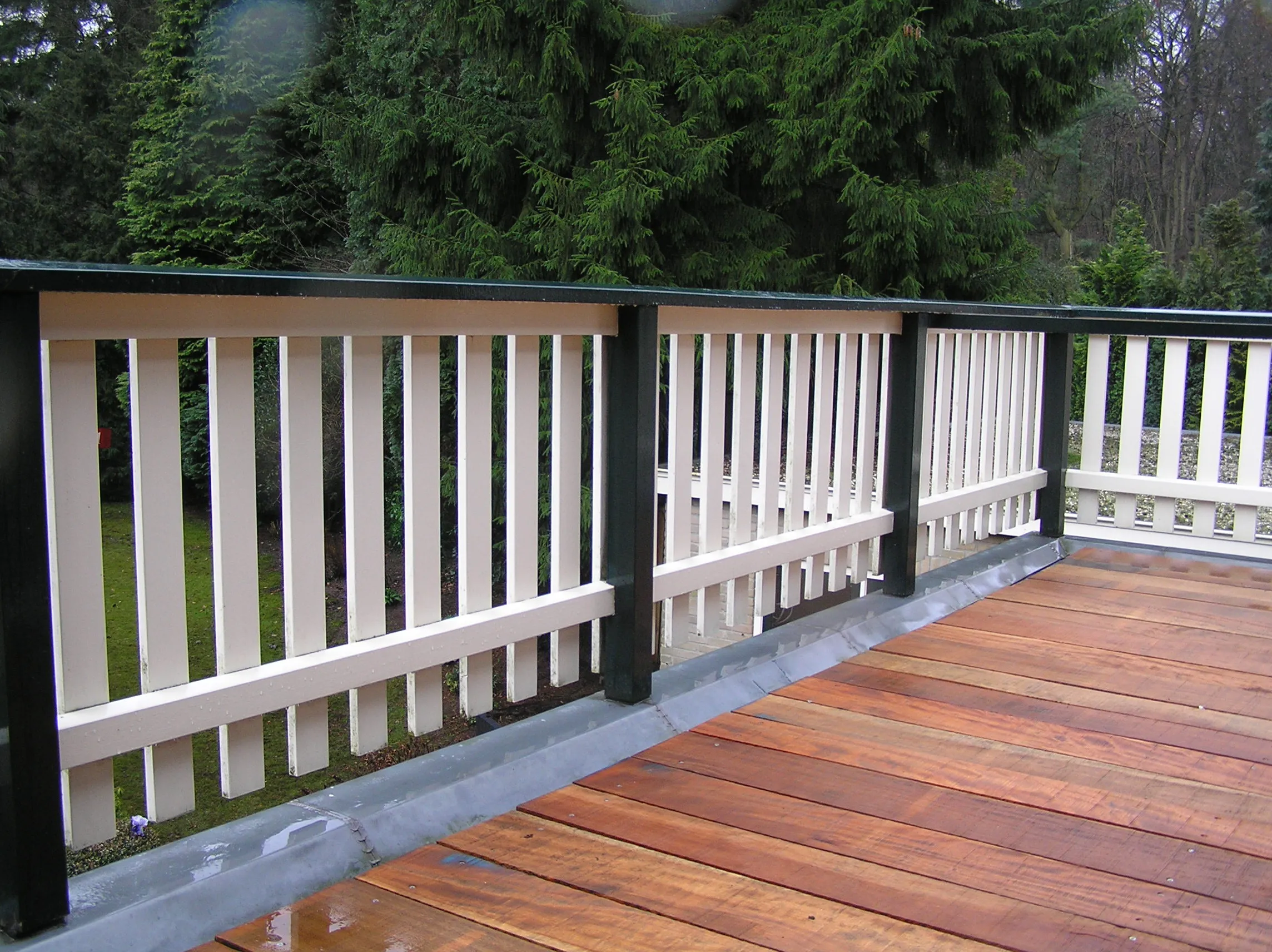 Houten vlonder met een fris witgelakte balustrade.