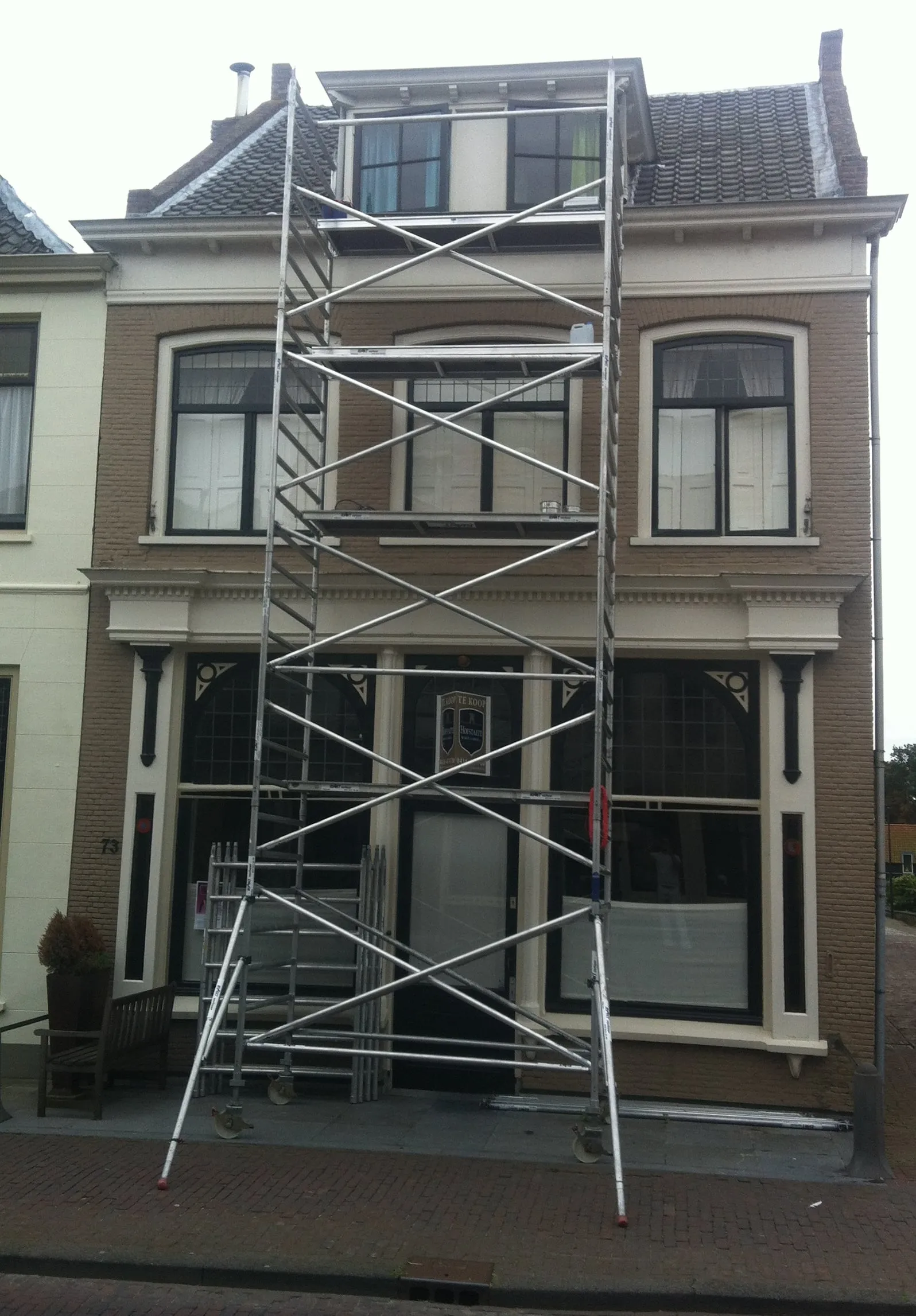 Monumentaal herenhuis in de steigers voor houtrotherstel en buitenschilderwerk.