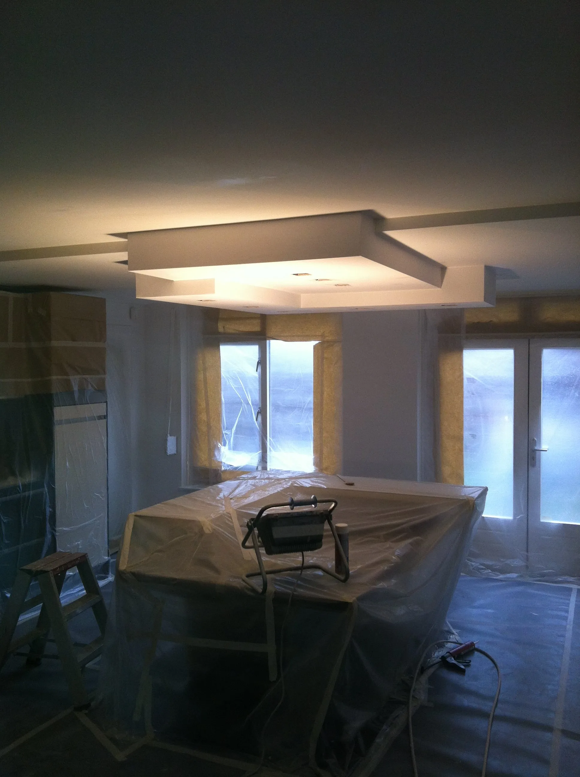 Plafond en lichtkoof strak gespoten; de inboedel is volledig ingepakt.