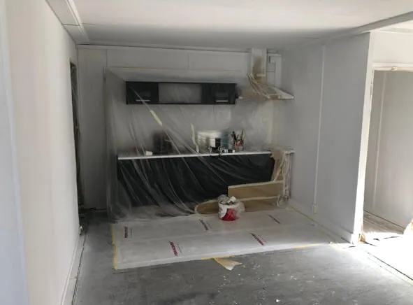 Keukenwand ingepakt en de vloer afgeplakt, klaar voor het spuitwerk.